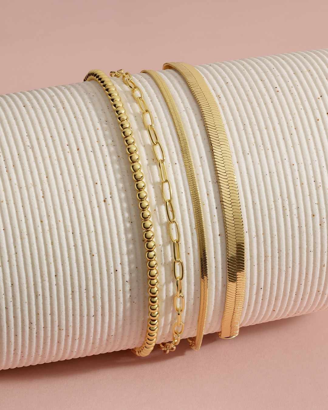 stack of gold bracelets on bracelet holder