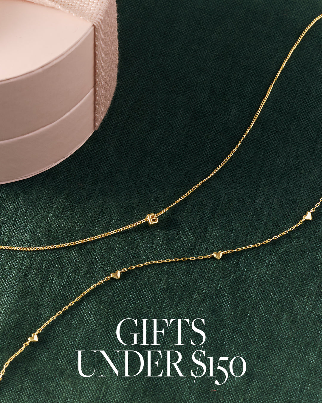 Two gold necklaces on a green surface with text 'Gifts Under $150'.
