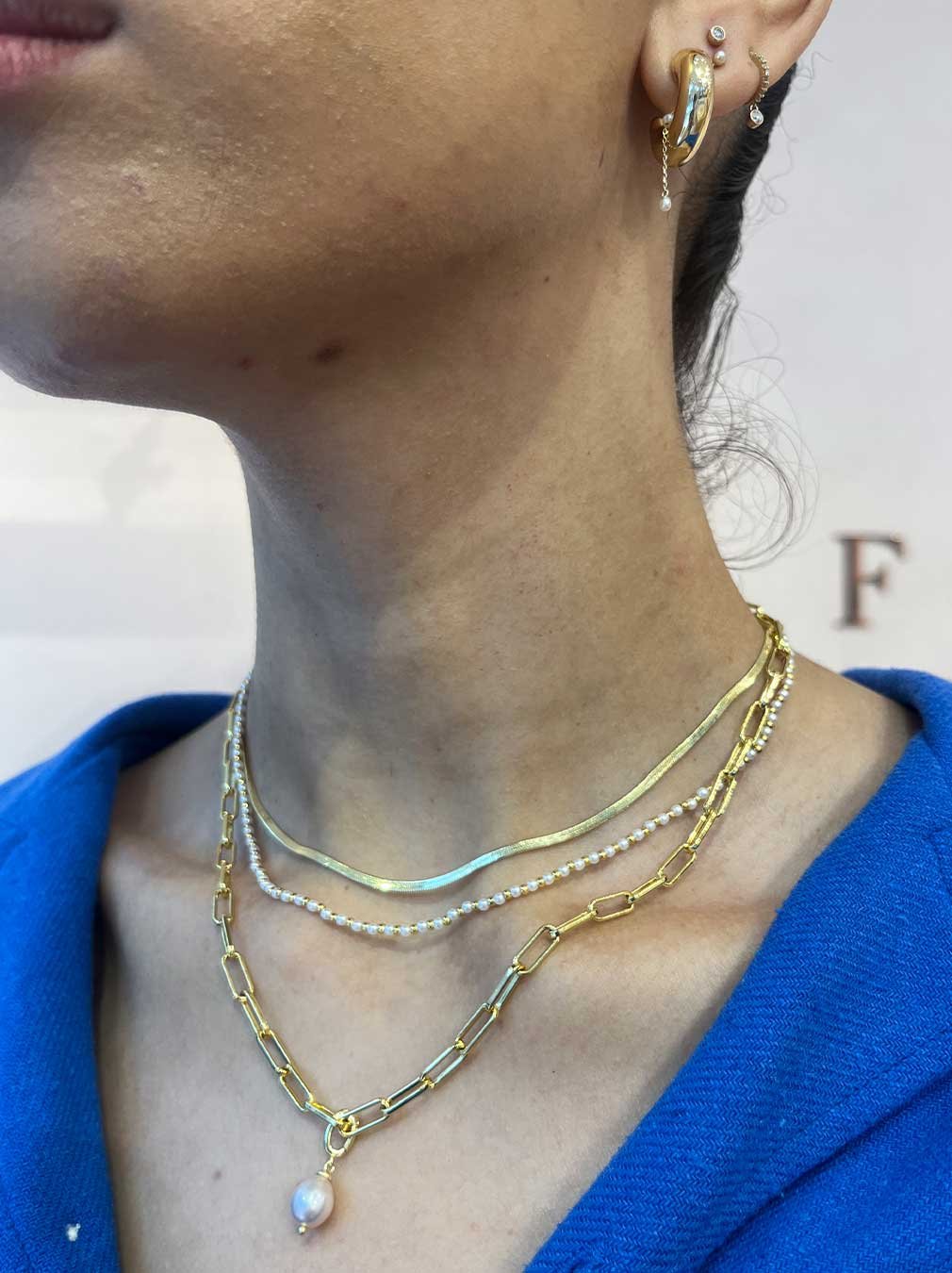 woman wearing gold plated earrings and necklaces