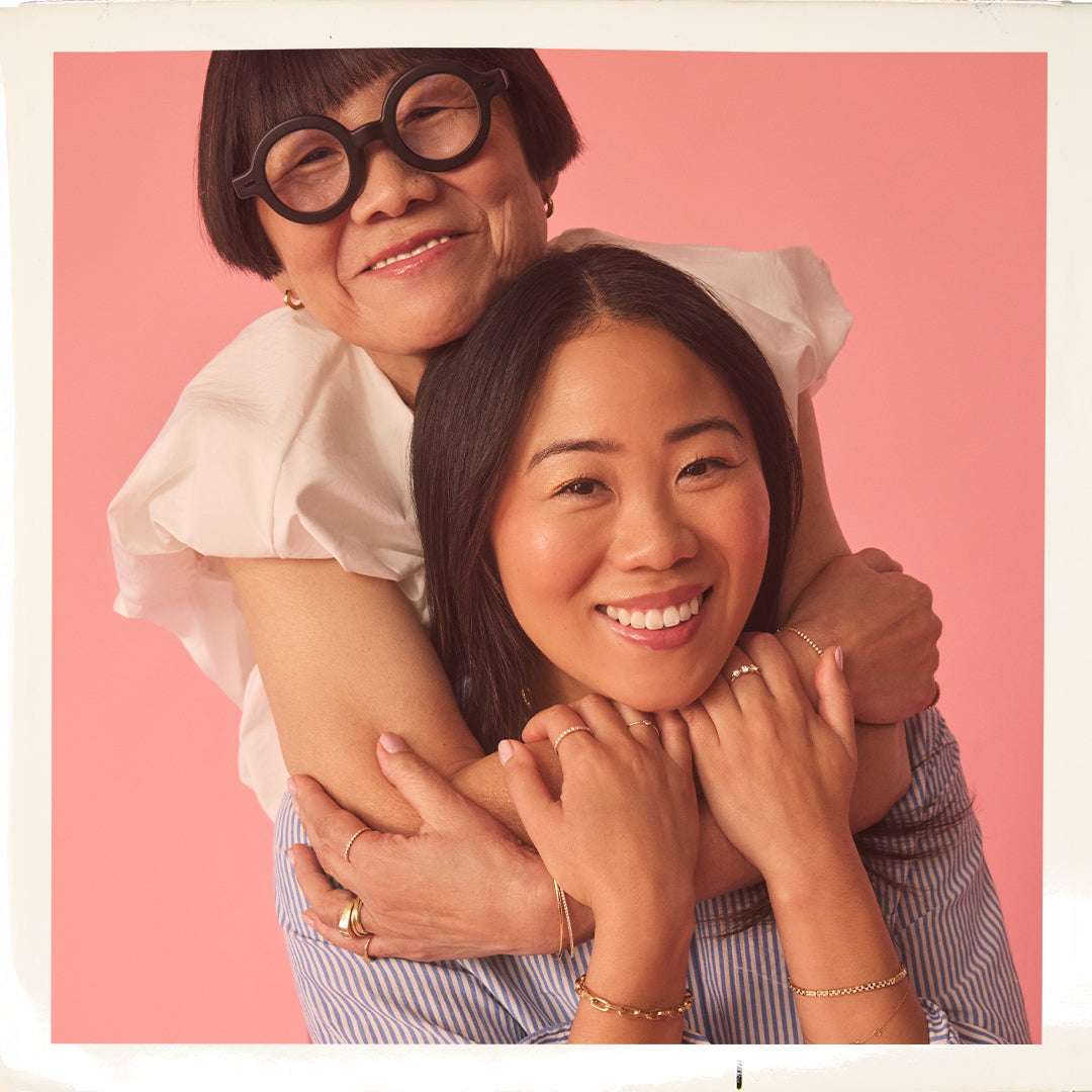 Two people embracing with a pink background