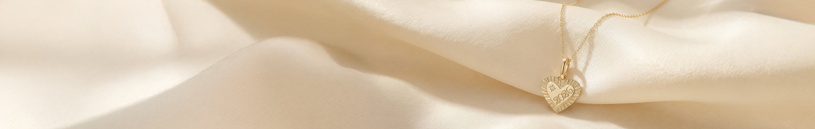 solid gold heart charm with '2026' on it 