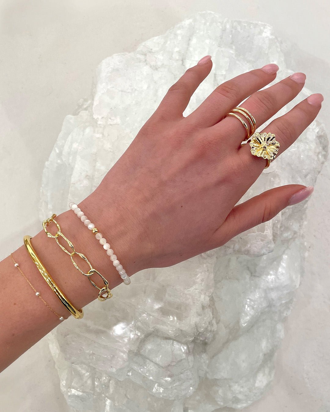 Stylist wearing gold plated and gemstone bracelets and rings