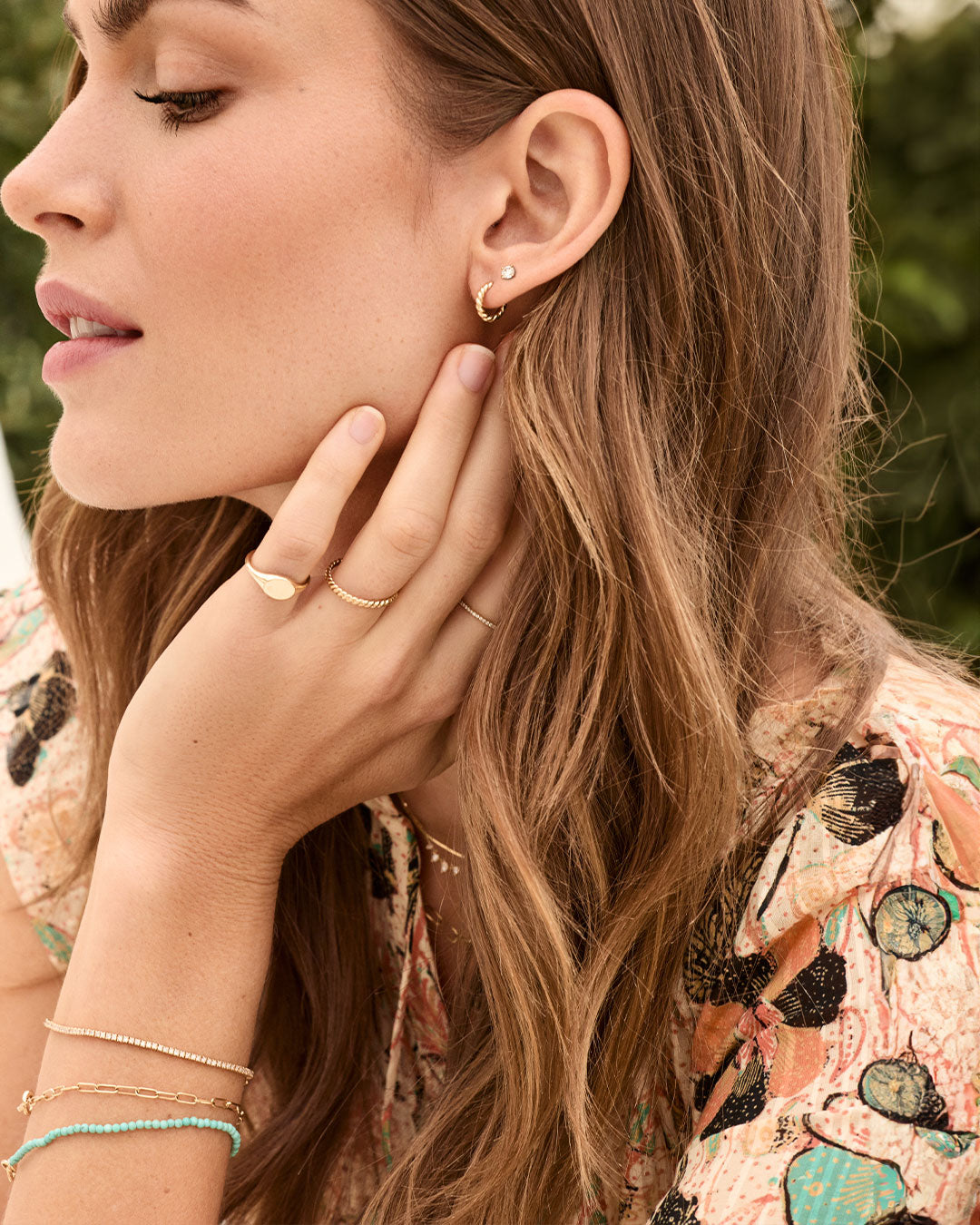 woman in summer floral top with bracelet stack