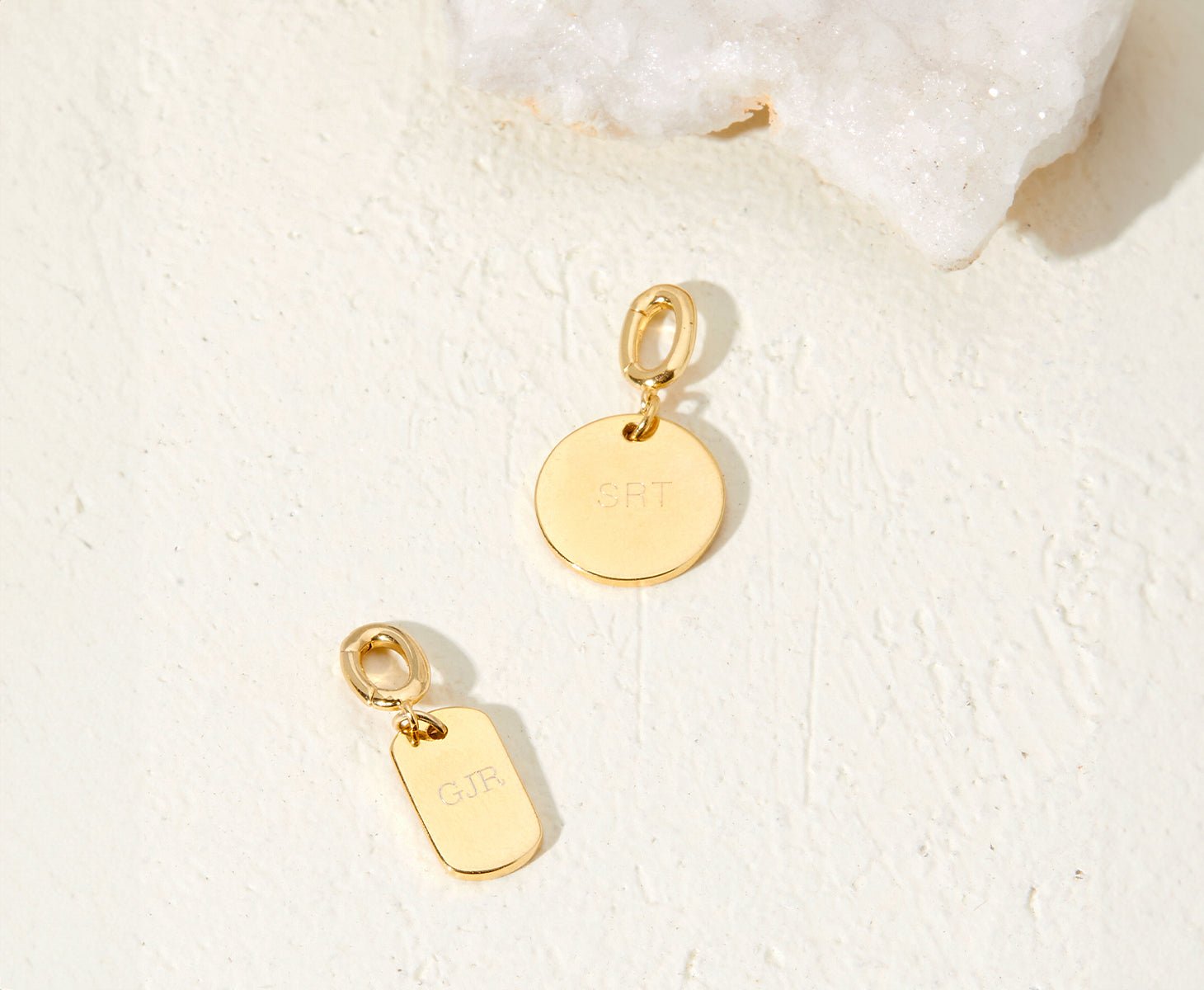 Two gold charms with initials engraved