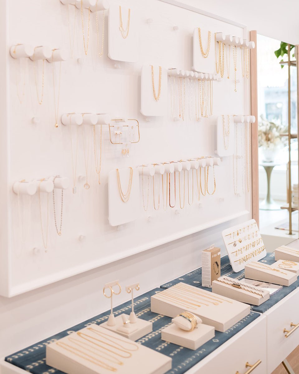white wall with jewelry on pegs
