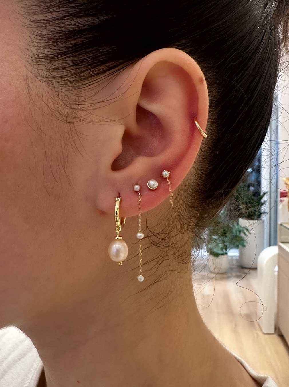 Woman wearing various pearl earrings