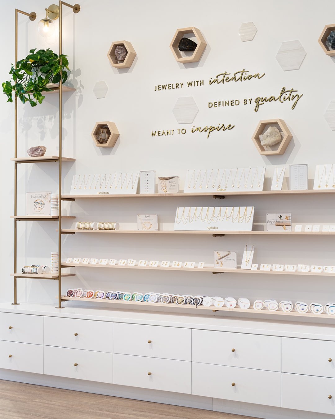 Interior of store with white wall filled with jewelry shelves and cases below