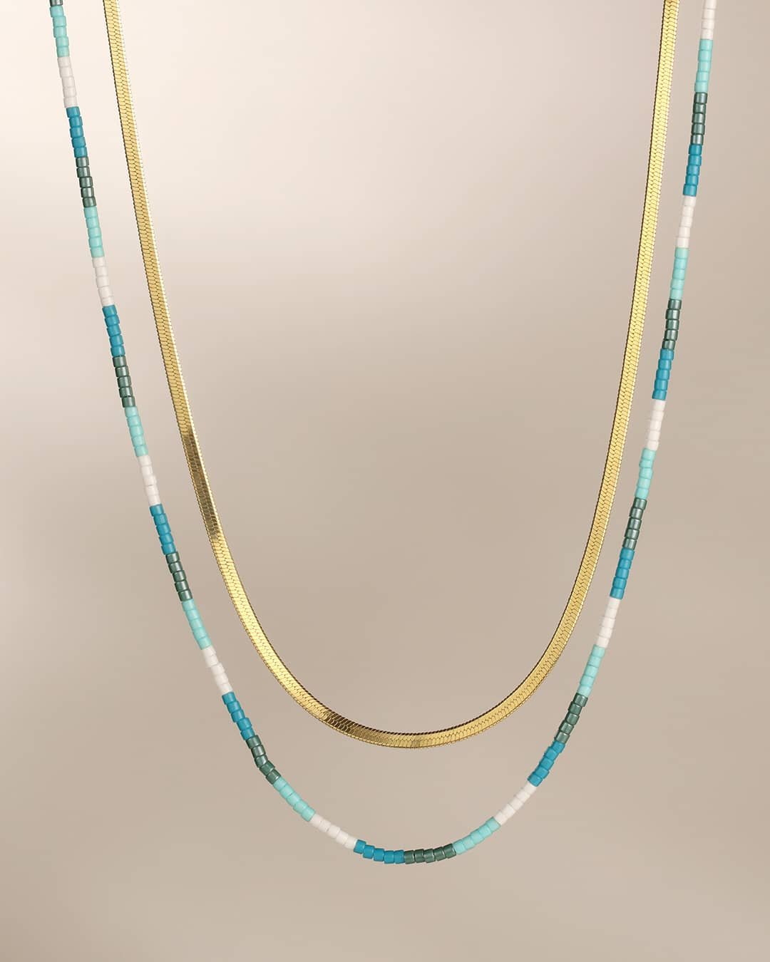 blue colorful necklace paired with gold necklace