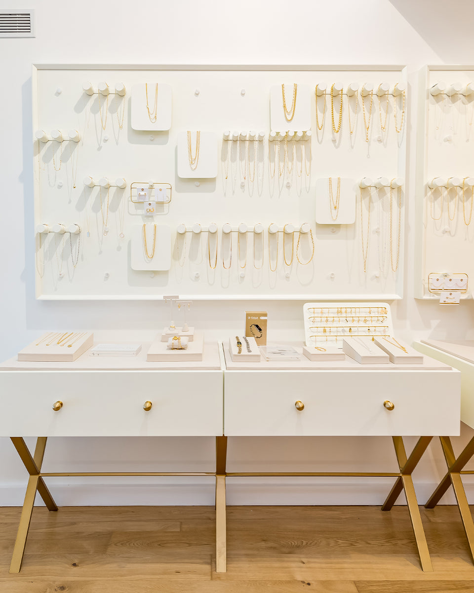 white wall with jewelry on pegs