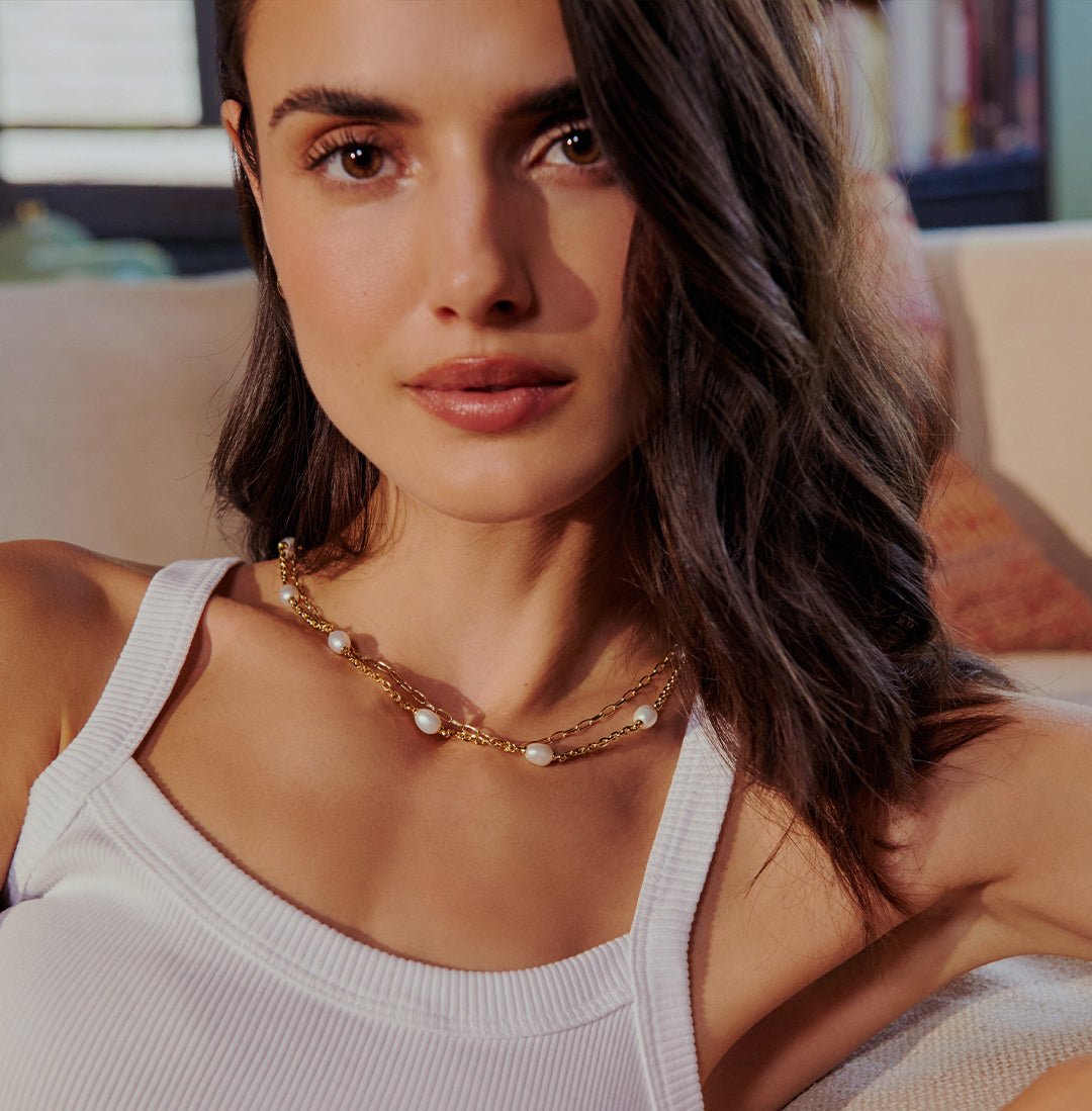 woman in white tank with chunky pearl necklace