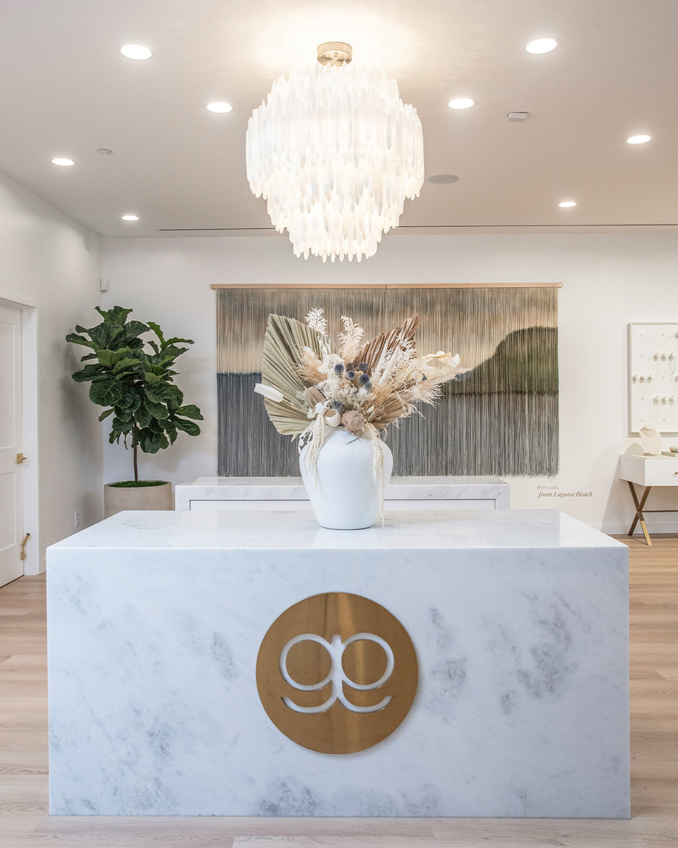 inside of gorjana store with big marble counter and white chandelier