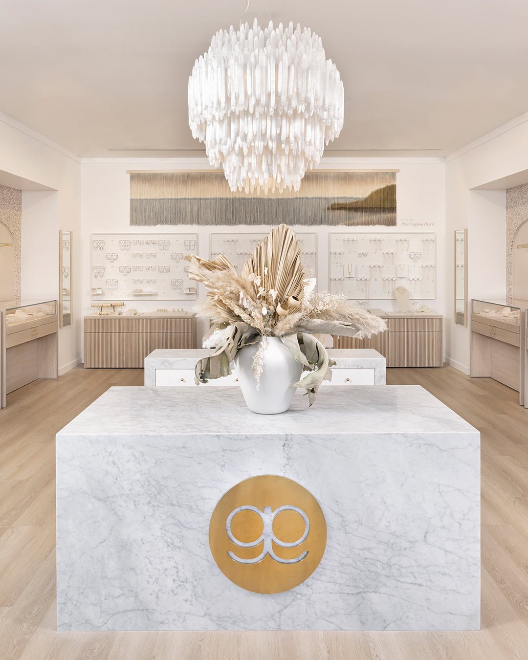 interior of gorjana store with marble counter with gorjana logo and big white chandelier