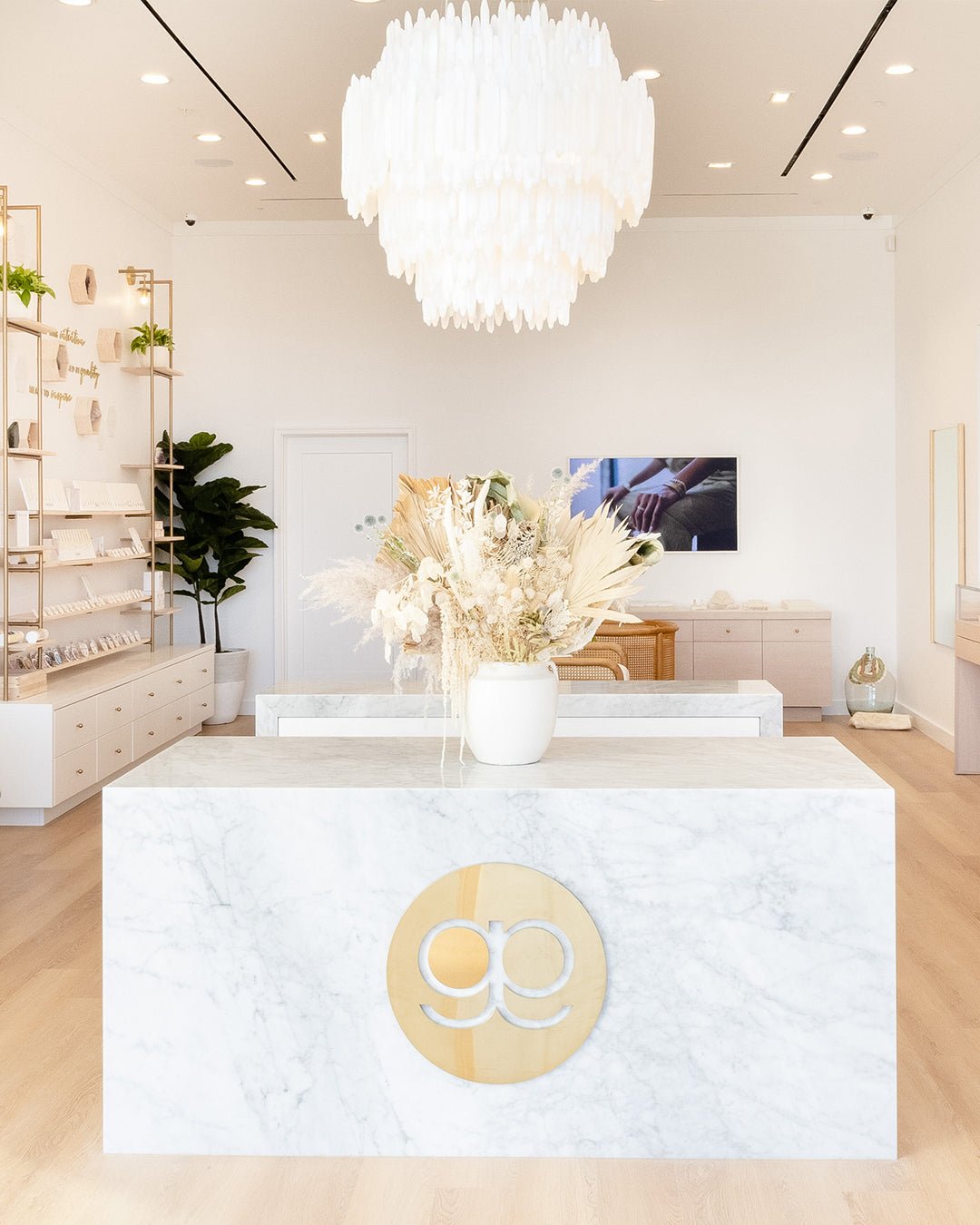 gorjana store with white marble counter and white chandelier 
