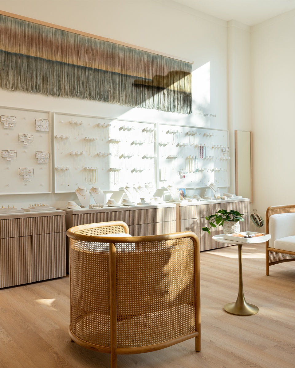 gorjana store with cozy wooden chairs with white cushions. beachy vibes