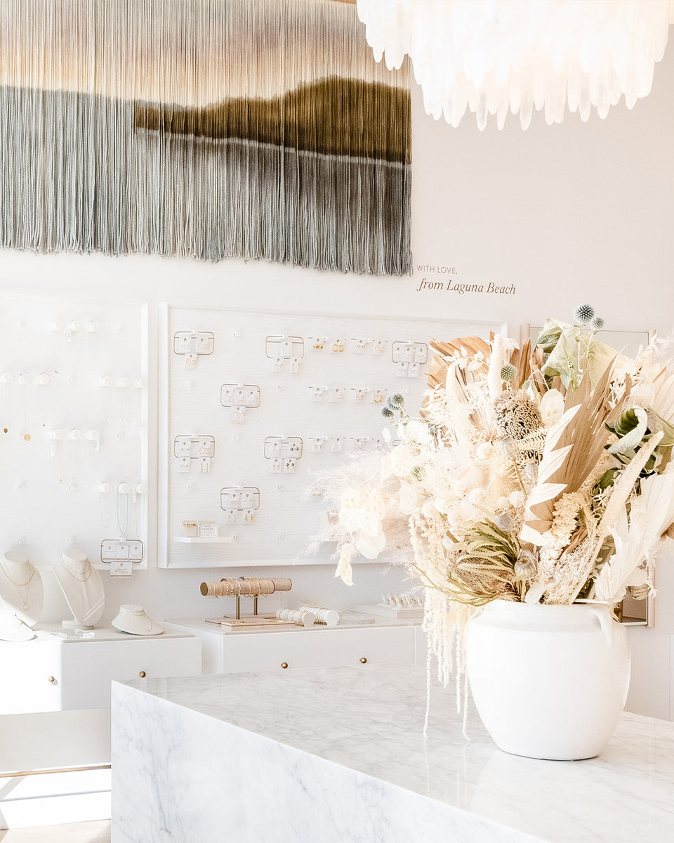 gorjana store with boho dried flowers, jewelry wall and ocean scape art piece