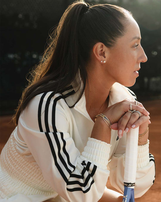 Jessie Pegula holding a tennis racket in fien jewelry