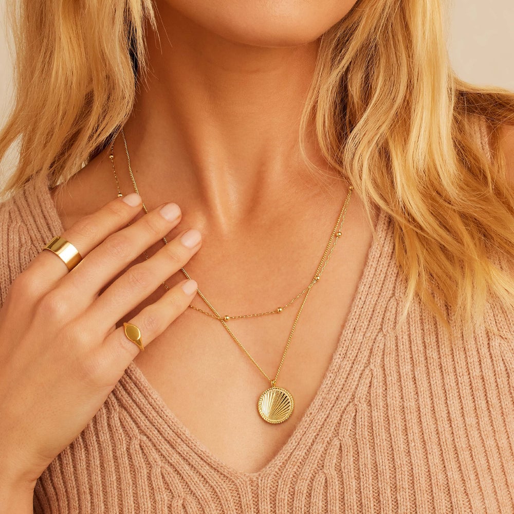 woman wearing gold layered necklace set 