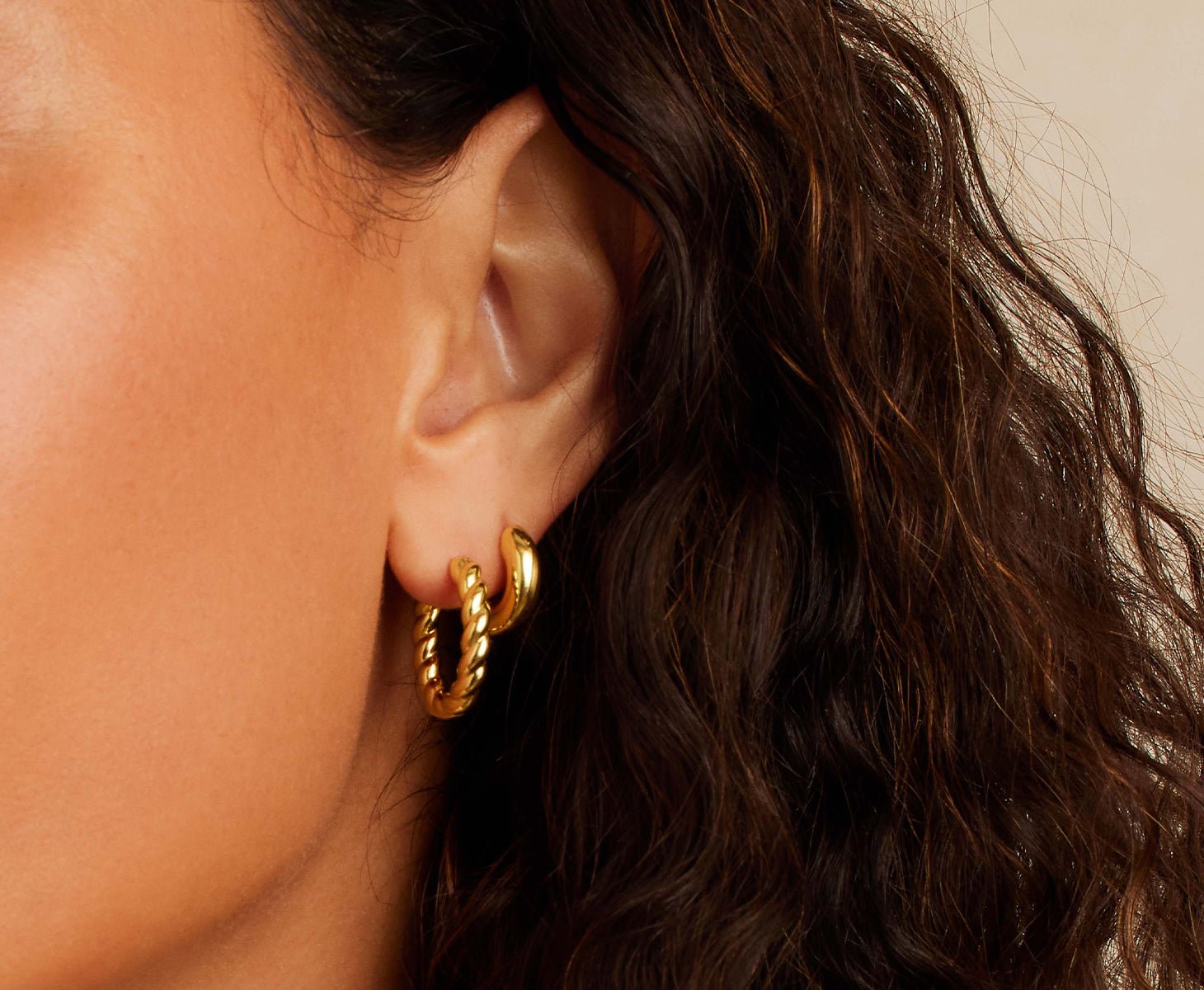 woman wearing set of gold earrings