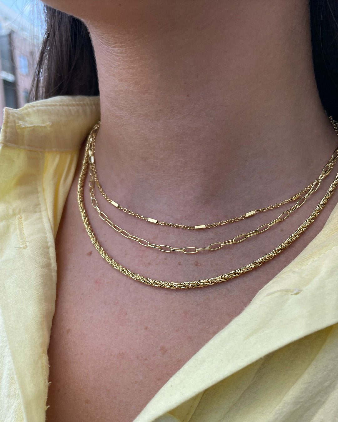 Woman wearing gold plated chain necklaces. 