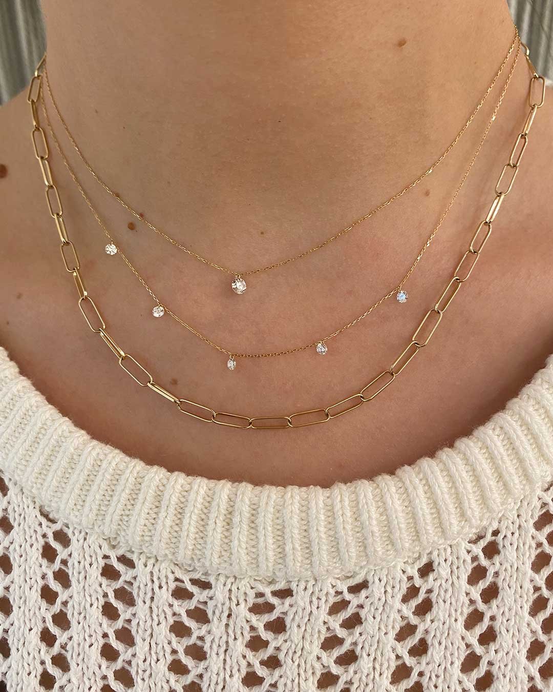 Stylist wearing The Floating Diamond Statement Necklace, Floating Diamond Flutter Necklace and 14k Gold Parker Necklace.  