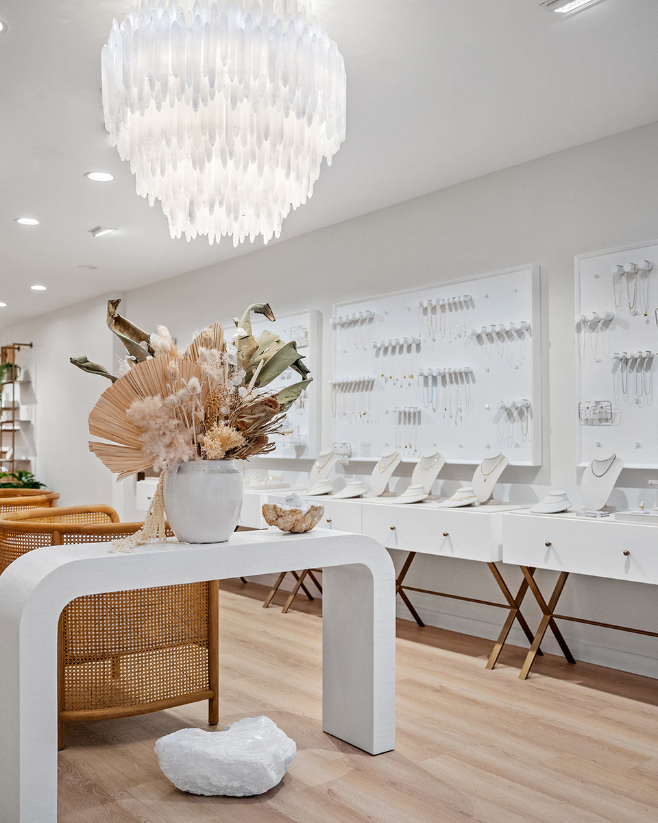 light and bright interior with jewelry on walls, white chandelier and boho dried flowers