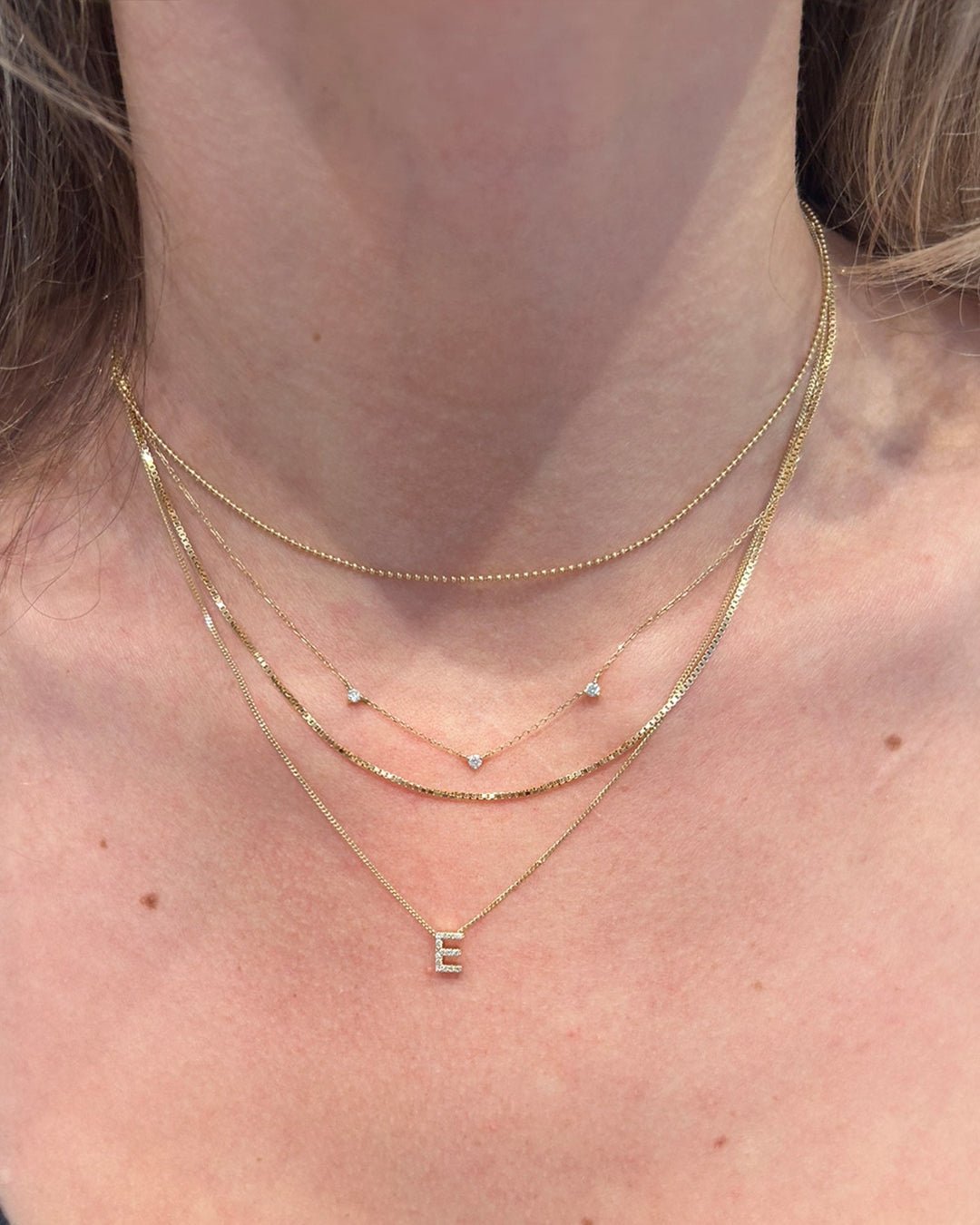 Woman wearing 14k and 18k solid gold necklaces. 