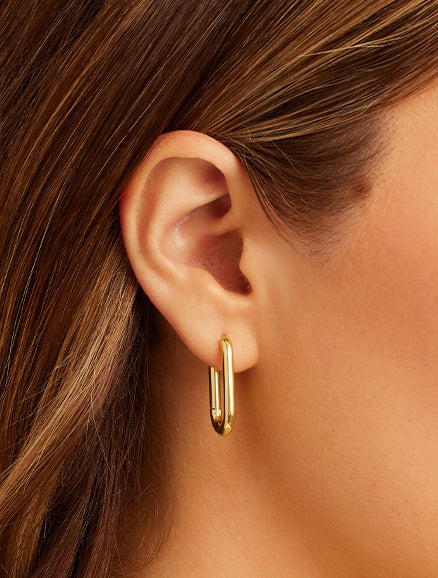 Woman wearing gold chain paper clip earrings. Shop earrings. 