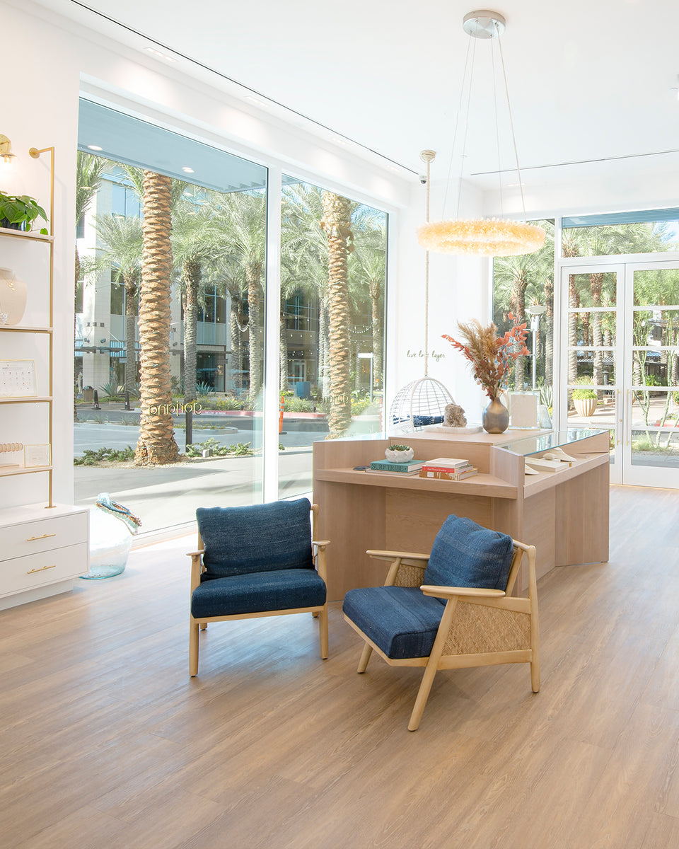 gorjana seating area with big windows and palm trees outside