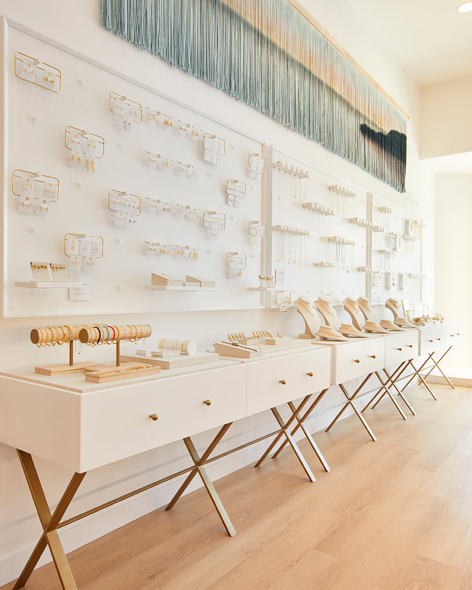 interior of gorjana store with white walls filled with jewelry and jewelry cases below