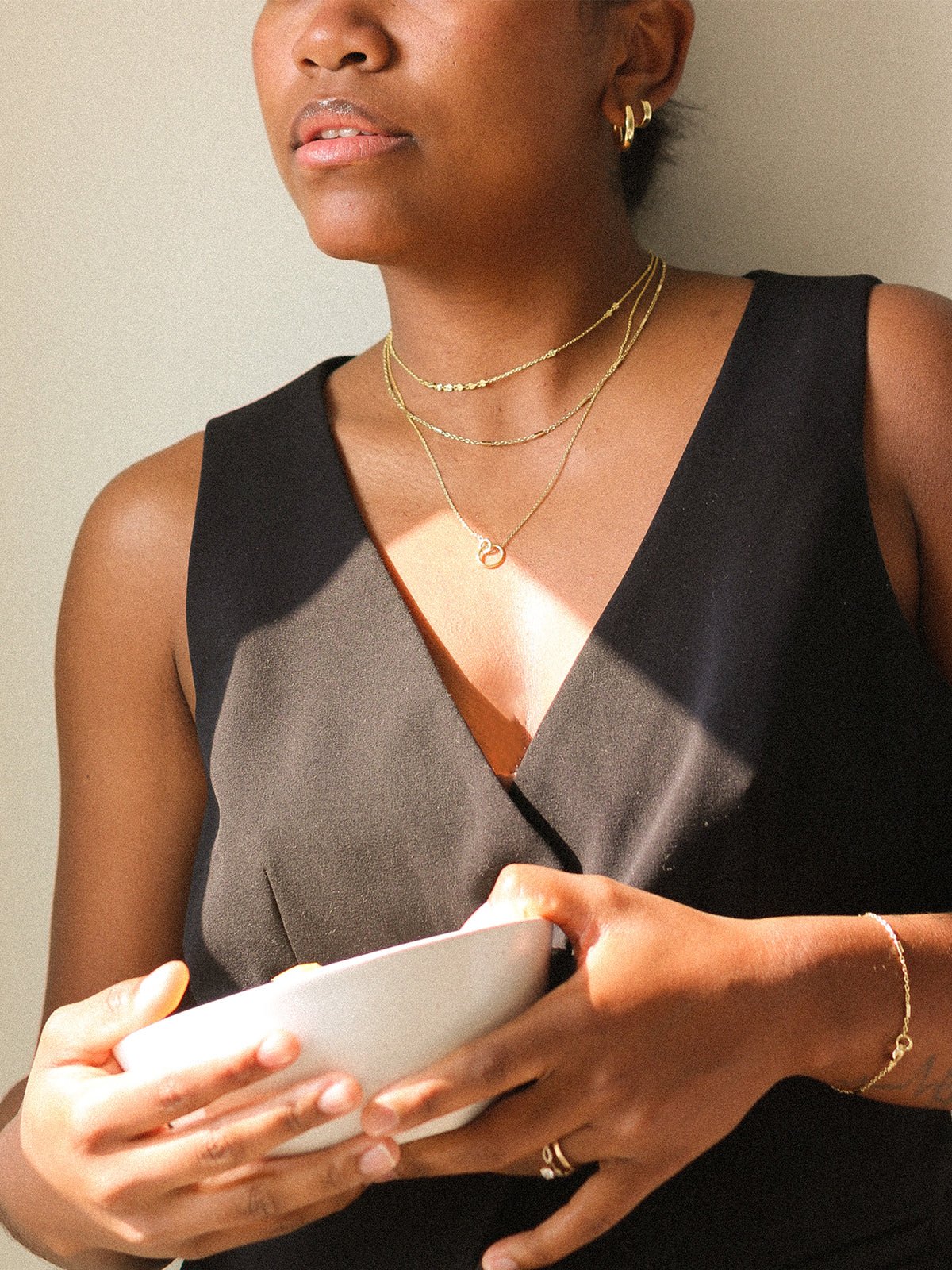 Woman wearing gold plated necklaces and bracelet. 