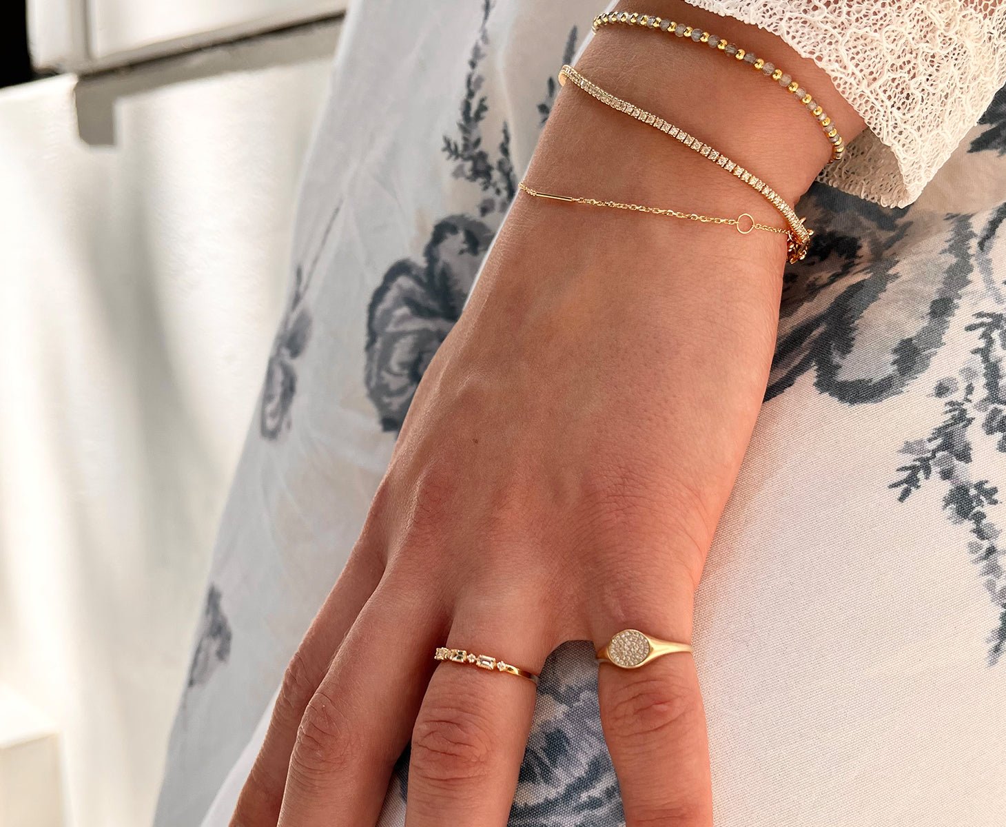 Woman wearing 14k solid gold rings and bracelets.