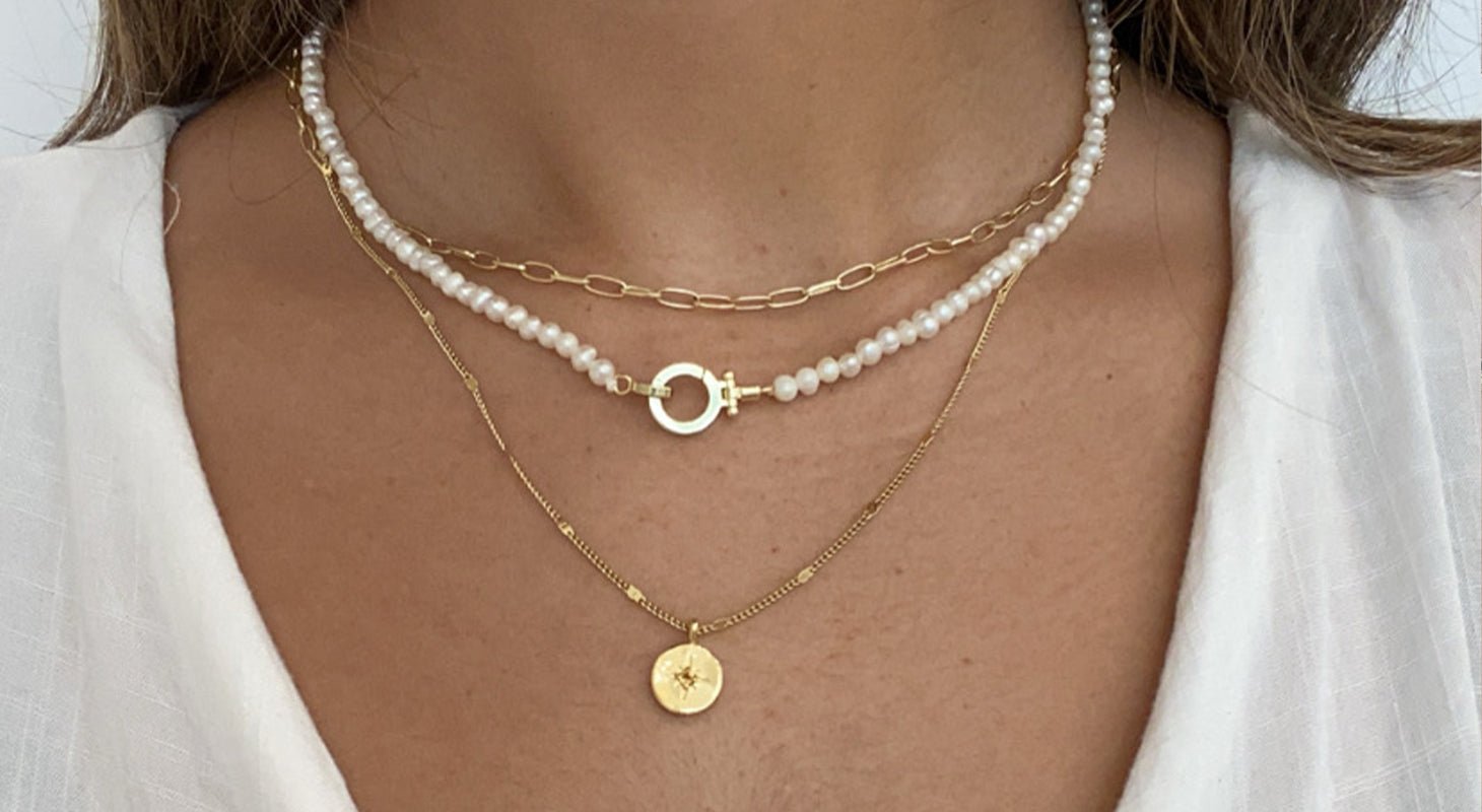 Woman wearing gold plated chain and pendant necklaces.