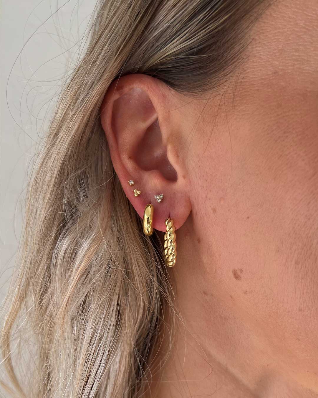 @ashawilkins in the 14k Gold Trio Flat Back Studs, Diamond Bali Flat Back Studs, Lou Huggies, and Crew Hoops.