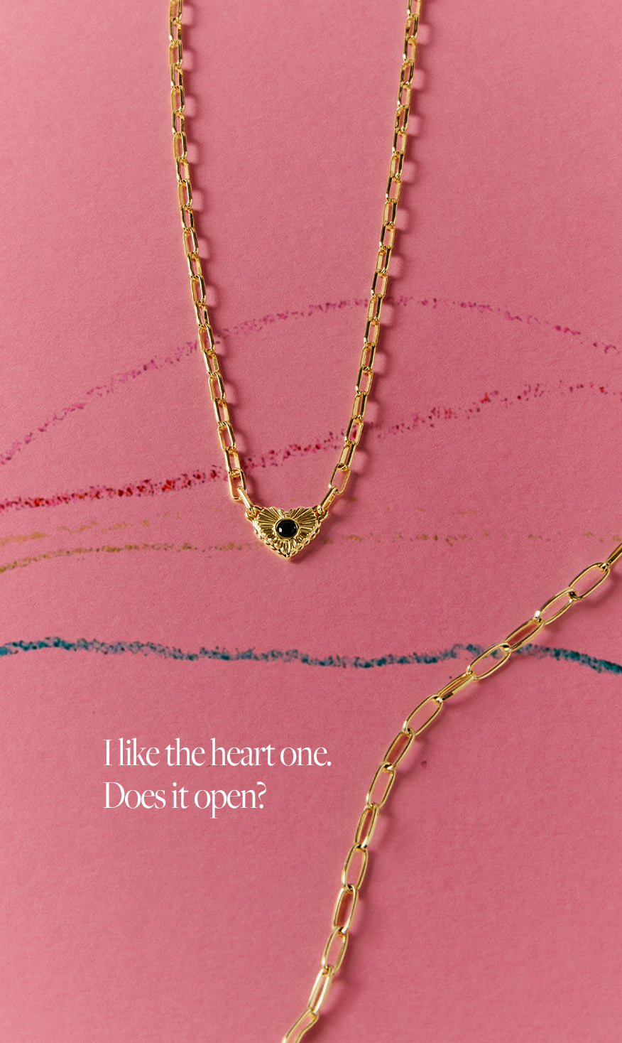 Gold necklace with a heart-shaped clasp on a pink background