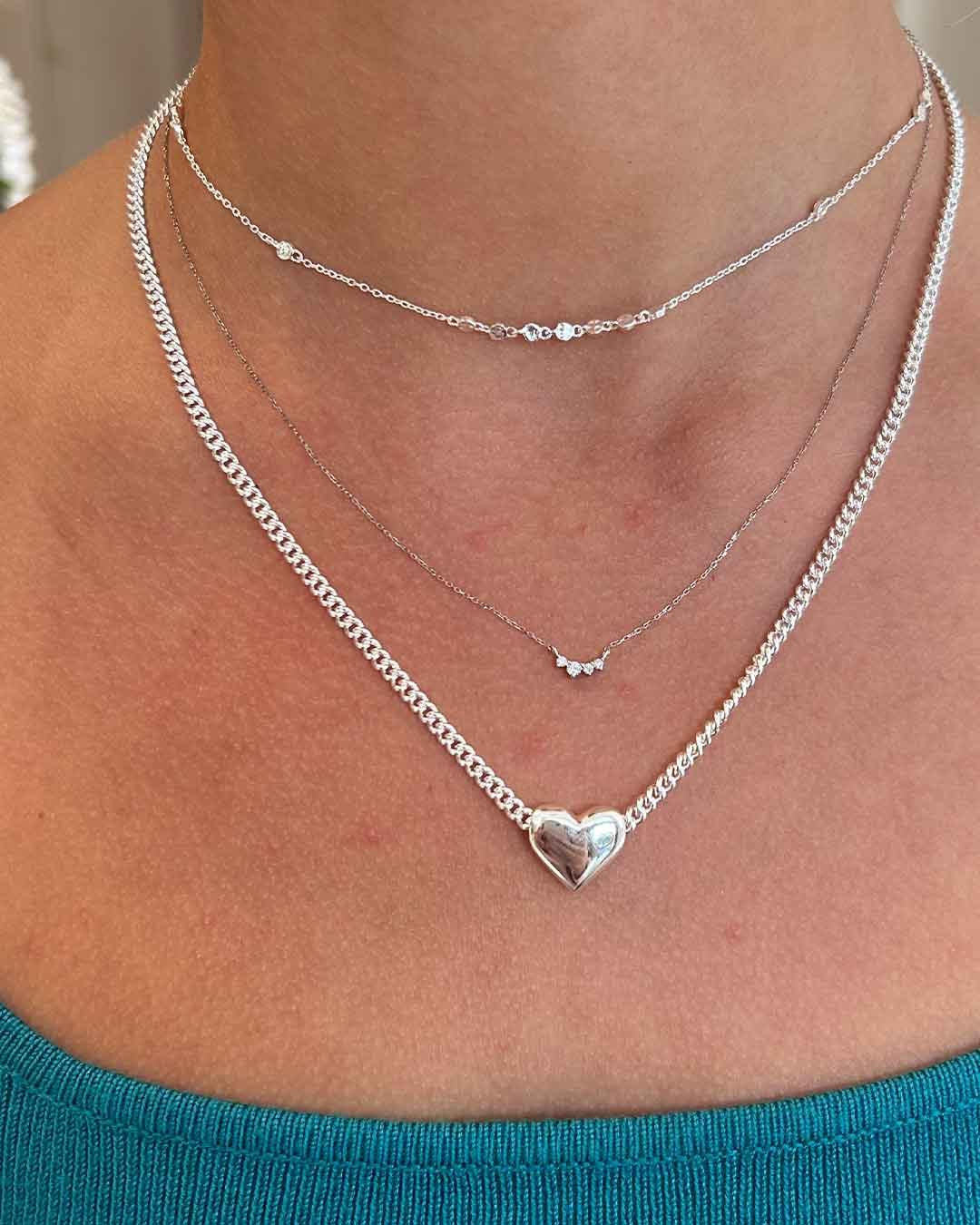 Woman wearing silver plated and white gold necklaces.
