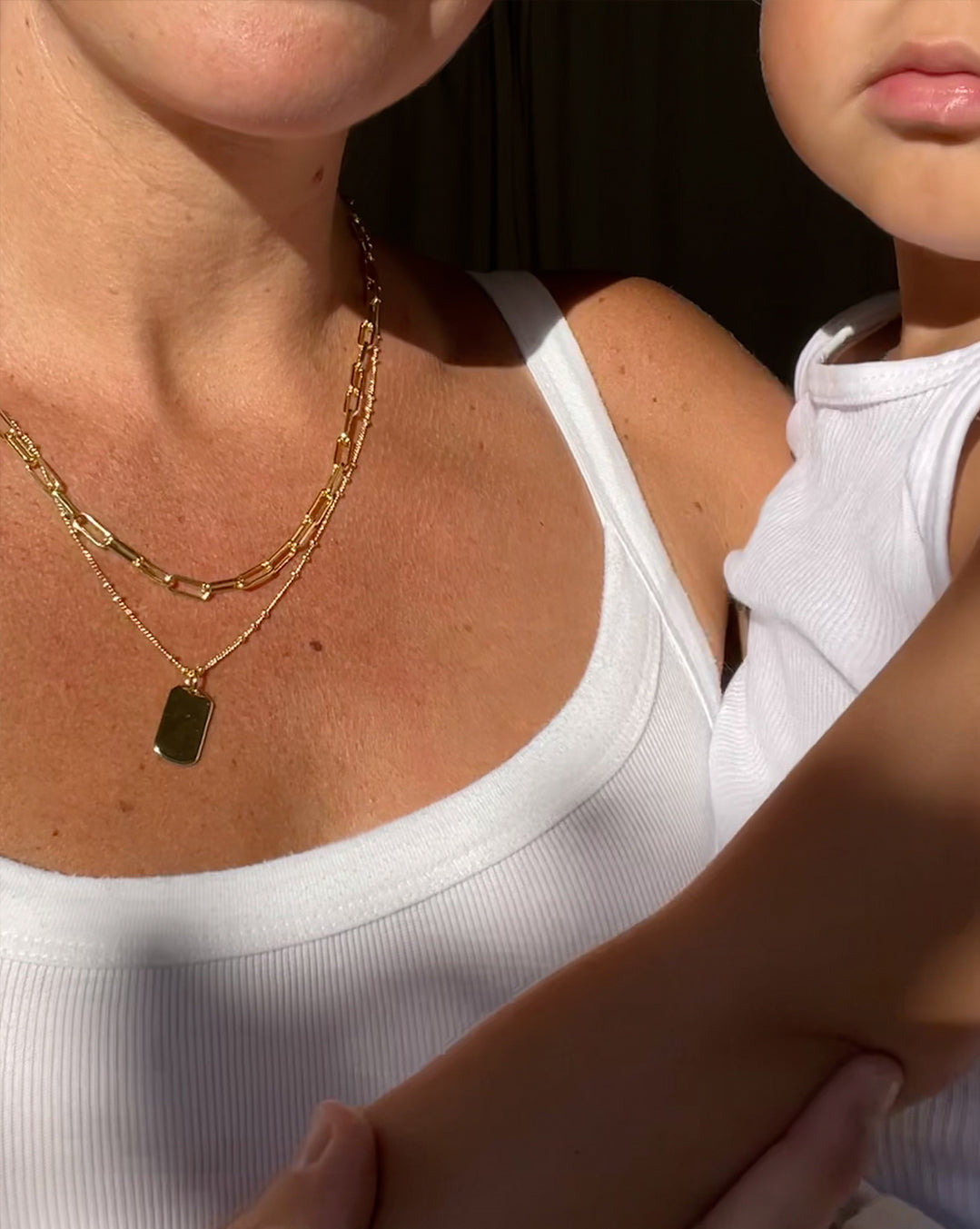 Woman holding her baby wearing the Parker Layering Set