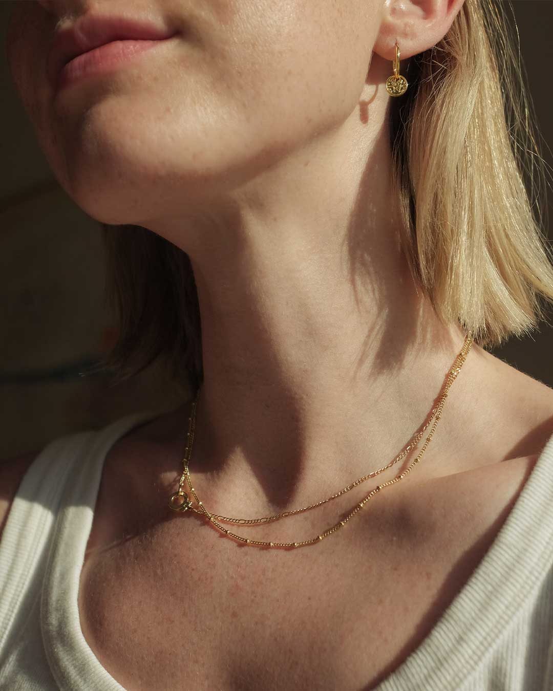 woman in gold necklaces