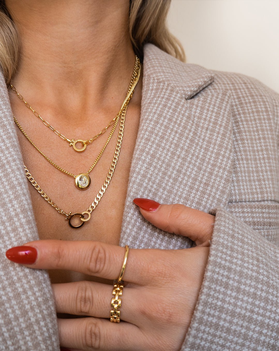 Woman wearing gold plated chain necklaces and rings